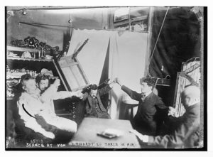 Spiritualist séance with levitating table